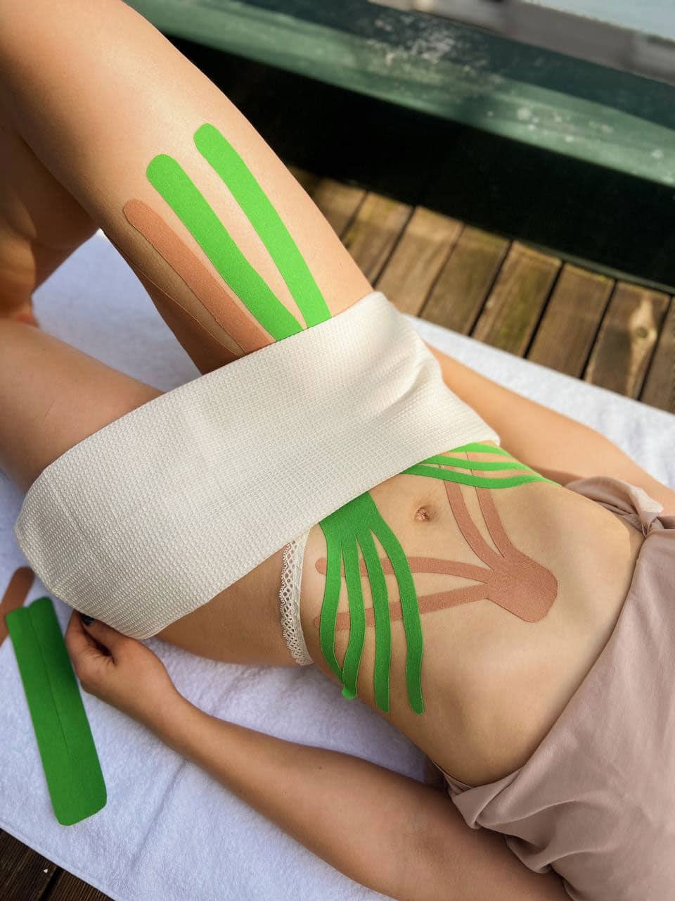 Aplicación de vendaje neuromuscular en zona lumbar y abdominal para aliviar tensiones y mejorar la recuperación muscular